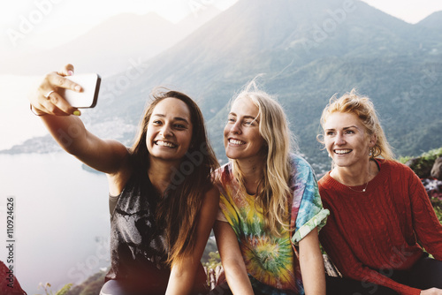 Three female friends taking smartphone selfie at Lake Atitlan, Guatemala photo