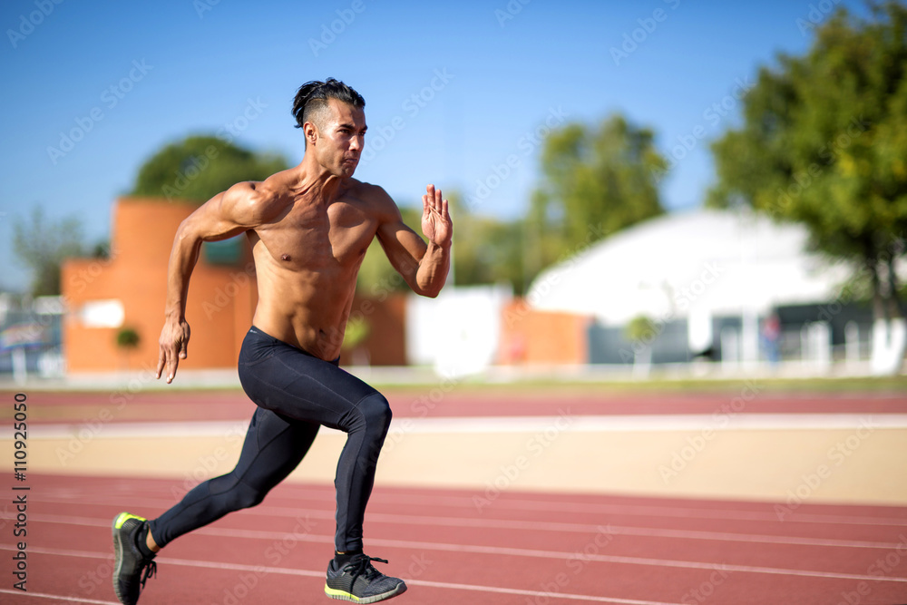 Obraz premium Young muscular man ready to start a track meet.