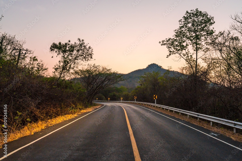 curve tarmac road in the mountains with evening clear sky at countryside