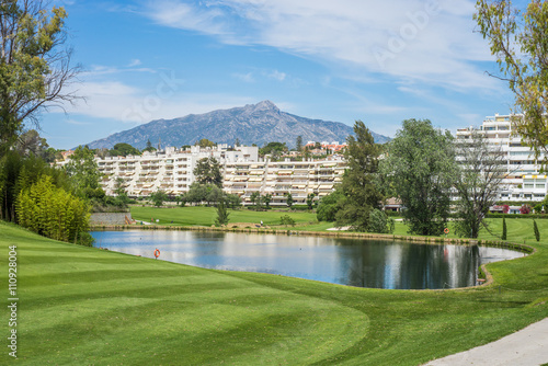 Golf course lake with mountain in the background.