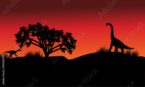 At morning silhouette eoraptor and brachiosaurus
