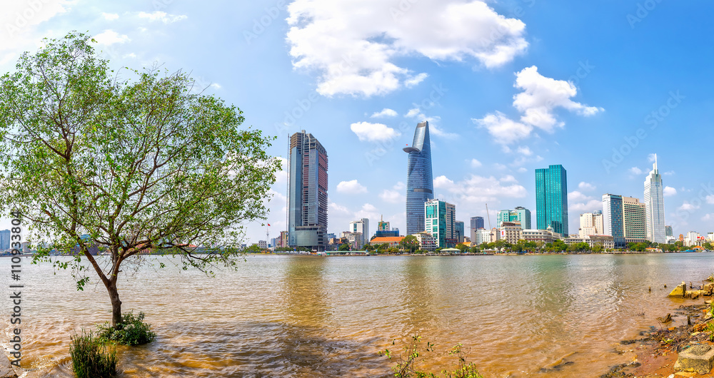 Panorama skyscrapers riverside sunny day, in front of riparian cork toward busy urban expressed economic development in opening up Ho Chi Minh city, Vietnam Panorama skyscrapers riverside sunny day, in front of riparian cork toward busy urban expressed economic development in opening up Ho Chi Minh city, Vietnam