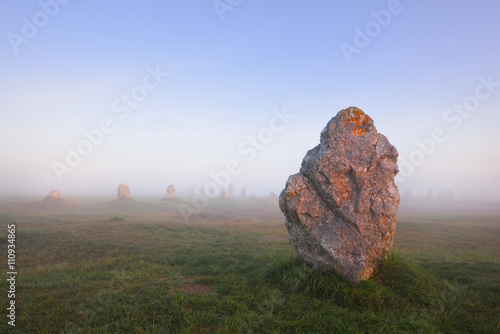 Single menhir view at Camaret sur mer at sunrise during fog photo