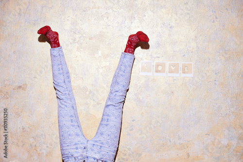 Studio shot of young womans legs upside down against wall