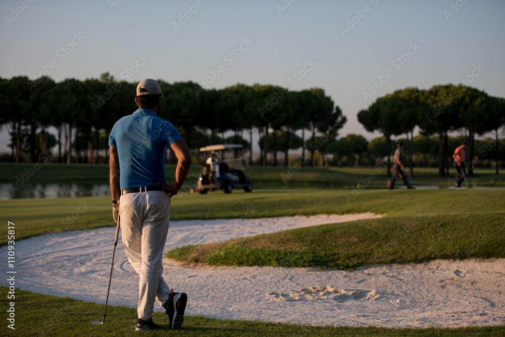 Obraz premium golfer from back at course looking to hole in distance