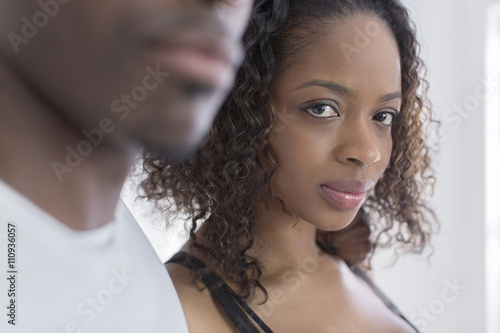 Studio portrait of confident young woman next to boyfriend photo