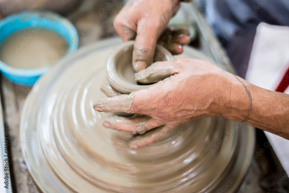 Clay potter creating on the pottery wheel Clay potter creating on the pottery wheel