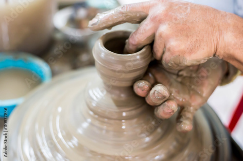 Clay potter creating on the pottery wheel