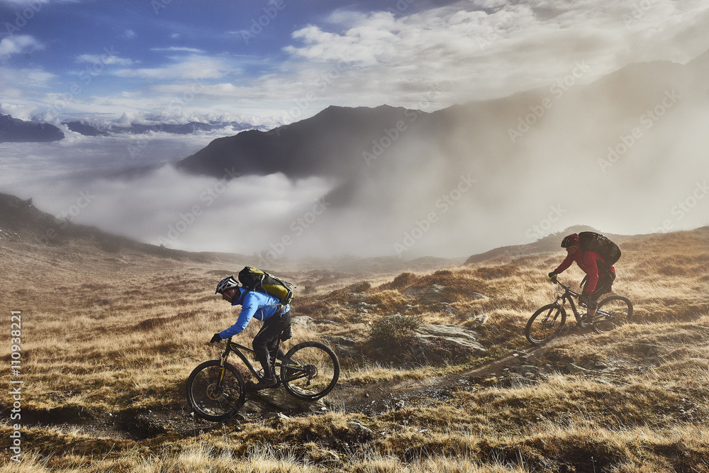 © Connect Images - Two men mountain biking in landscape