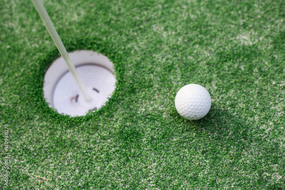 Naklejka premium golf ball on lip of cup