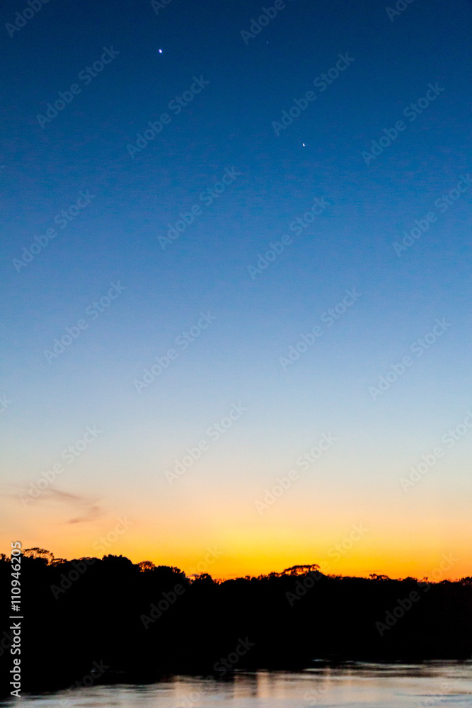 View of a sunset over Amazon river in Brazil. Planets Venus and Jupiter are also visible.