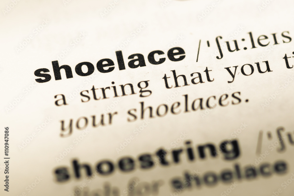 Close up of old English dictionary page with word shoelace