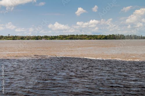 The Meeting of Waters (Encontro das Aguas) is the confluence between the Rio Negro river, with dark water, and lighter Amazon river or Rio Solimoes photo