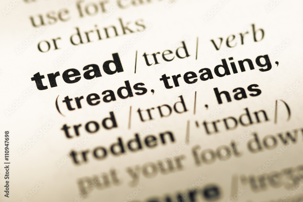 Close up of old English dictionary page with word tread Close up of old English dictionary page with word tread