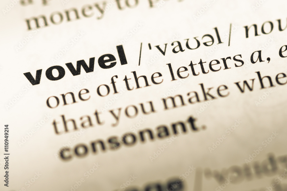Close up of old English dictionary page with word vowel Close up of old English dictionary page with word vowel