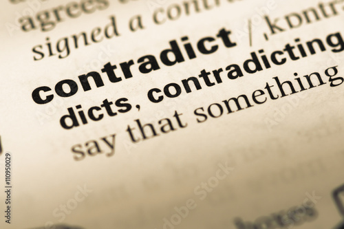 Close up of old English dictionary page with word contradict