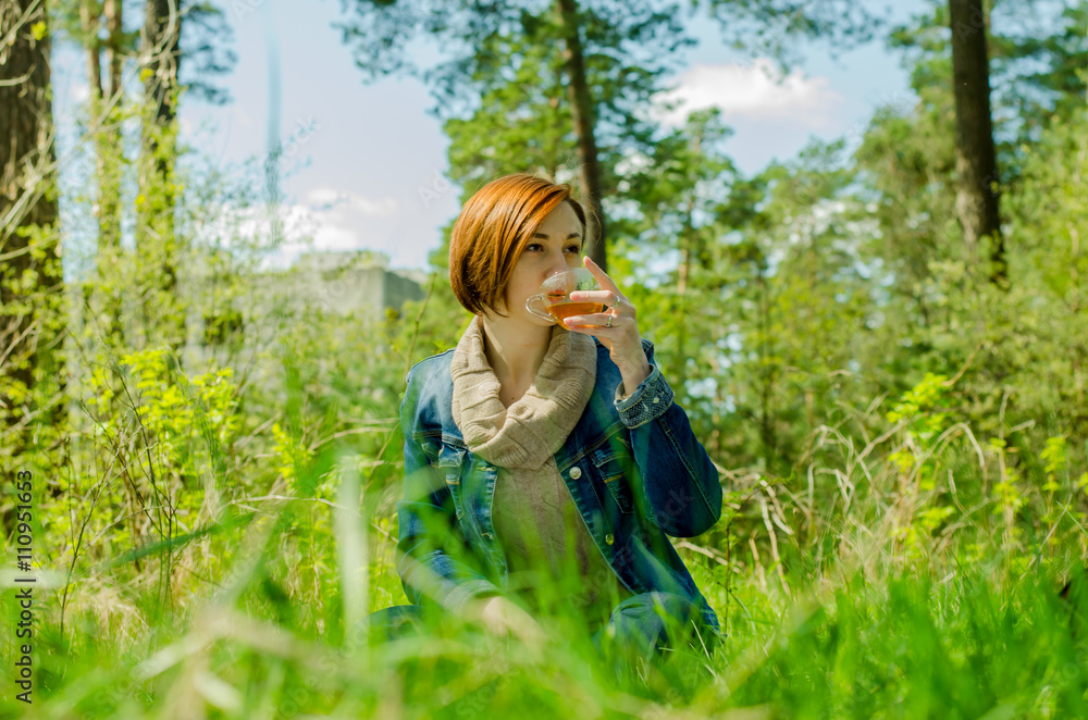 Beautiful girl and cup green tea in the forest Beautiful girl and cup green tea in the forest