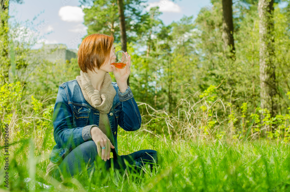 Beautiful girl and cup green tea in the forest Beautiful girl and cup green tea in the forest