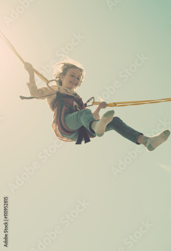 Photography Little girl on bungee trampoline with cords. Place for text.