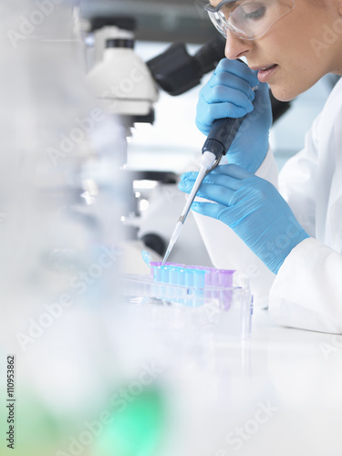 Female scientist pipetting sample into a vial for analytical testing in a laboratory