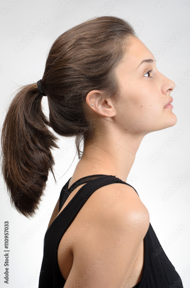 Portrait of a beautiful young woman standing against grey background Portrait of a beautiful young woman standing against grey background