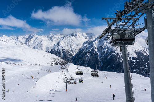 Skiers and double chairlift in Alpine ski resort in Solden 