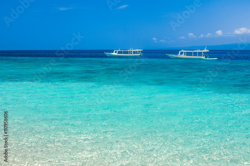 Beautiful beach and tropical turquoise sea with boats on horizon © GVS