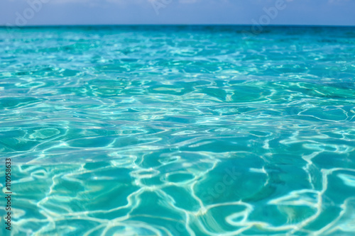 Tropical sea water with bright sun light reflections. Sea backgr