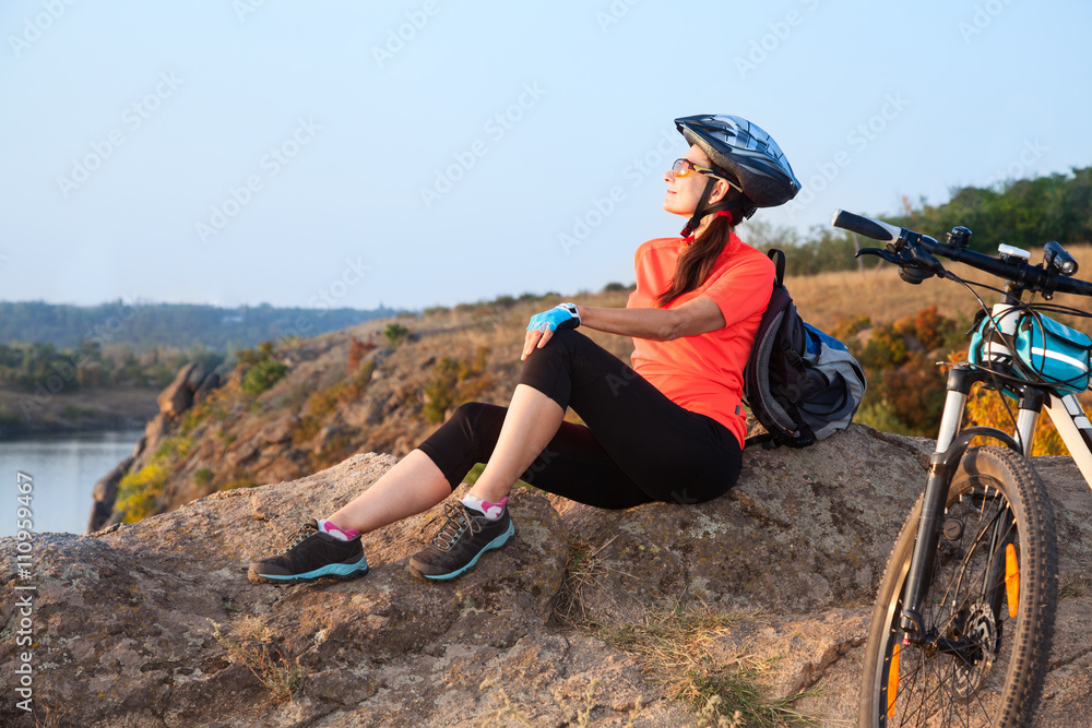 Adult attractive female cyclist is resting.