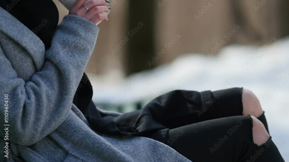 young girl drinking coffee in a winter park sitting on the bench young girl drinking coffee in a winter park sitting on the bench