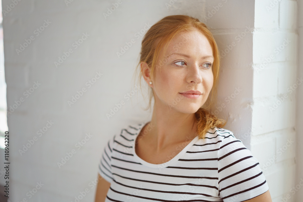 schöne junge frau schaut verträumt aus dem fenster foto de Stock