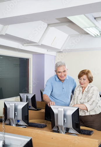 Happy Senior People Using Computer In Classroom