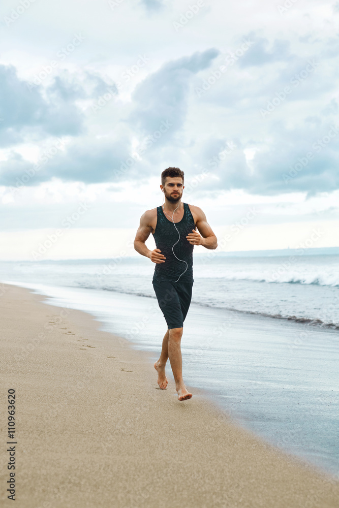 Sports. Handsome Fit Athletic Man Running On Beach. Sporty Runner Jogging Near Sea During Outdoor Workout. Healthy Active Jogger Exercising And Training For Marathon. Fitness Concept Sports. Handsome Fit Athletic Man Running On Beach. Sporty Runner Jogging Near Sea During Outdoor Workout. Healthy Active Jogger Exercising And Training For Marathon. Fitness Concept