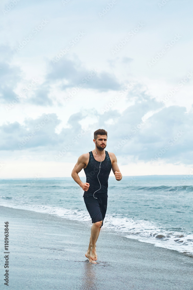 Running Man. Sporty Runner Enjoying Run By Sea During Outdoor Workout. Handsome Fit Athletic Male Jogging On Beach. Healthy Active Jogger Exercising And Training For Marathon. Fitness, Sports Concept