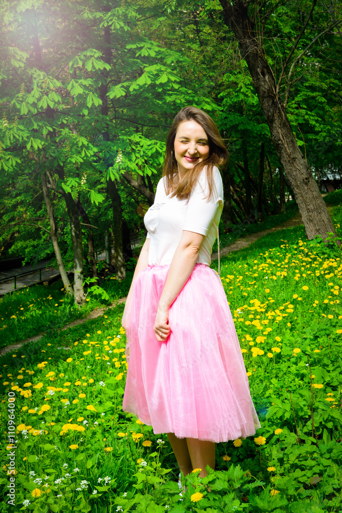 Beautiful sexy young hipster girl outdoors.Posh woman with long brunette hair evening makeup wearing light fluffy pink rosy skirt and vans sneakers posing outdoors in the city urban style in summer Beautiful sexy young hipster girl outdoors.Posh woman with long brunette hair evening makeup wearing light fluffy pink rosy skirt and vans sneakers posing outdoors in the city urban style in summer