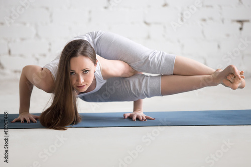 Portrait of beautiful woman doing eight angle handstand pose photo