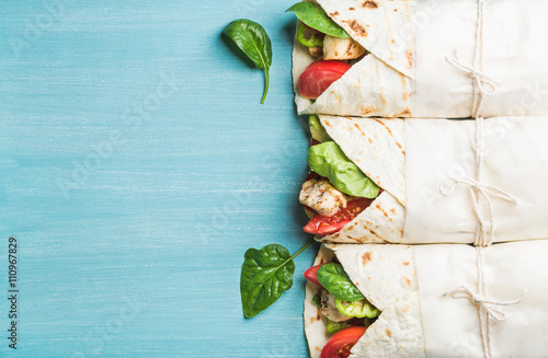 Healthy lunch snack. Tortilla wraps with grilled chicken fillet and fresh vegetables photo