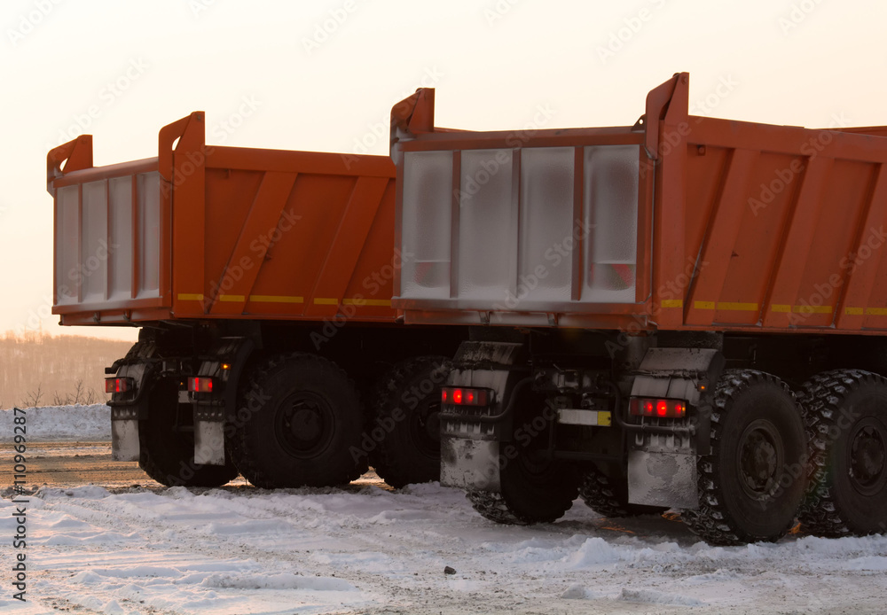 Two truck stay on snow near road. Two truck stay on snow near road.