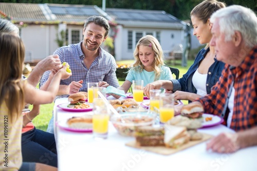 Happy multi-generation family eating at table