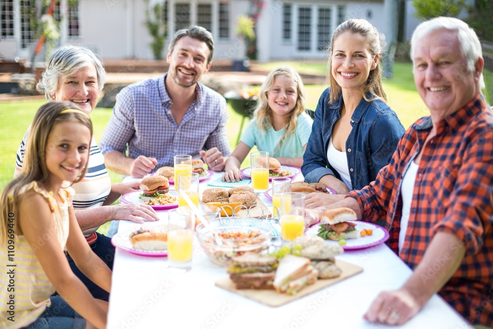 Portrait of cheerful family sitting at table Portrait of cheerful family sitting at table