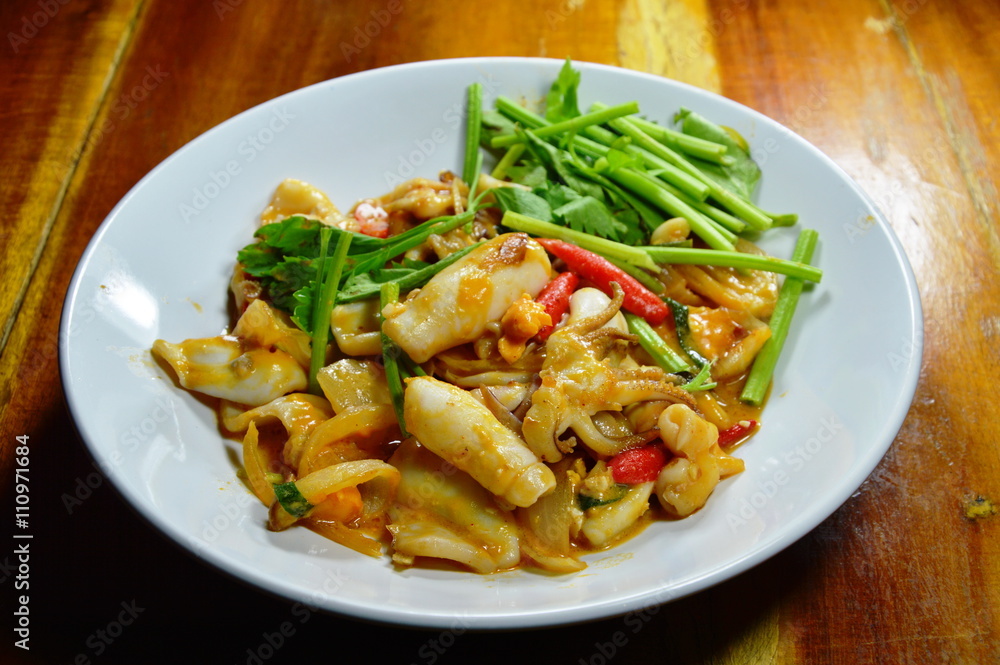 stir-fried squid with salt egg on white dish stir-fried squid with salt egg on white dish