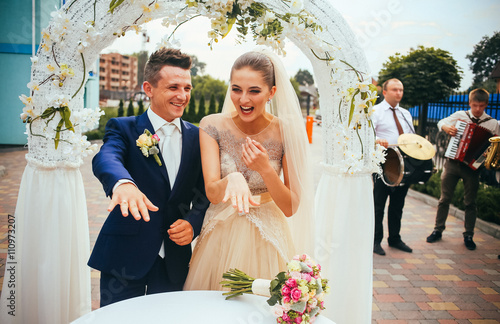 Stylish happy newlyweds on the wedding ceremony emotion after exchange rings outdoors