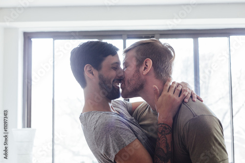 Male couple at home,fooling around, kissing and laughing