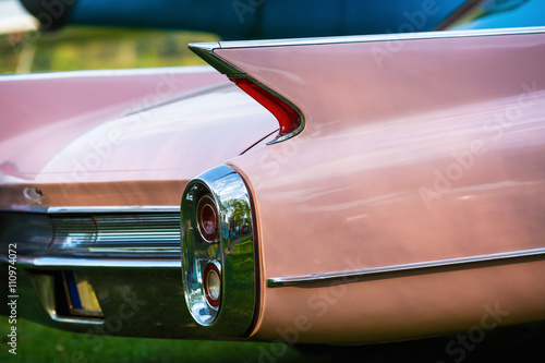 Close-up of the rear of the pink vintage car. Back view of retro car. Vintage pink car. Detail of a vintage car. Selective focus.