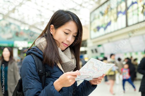 Canvas Print Woman look at map in train station