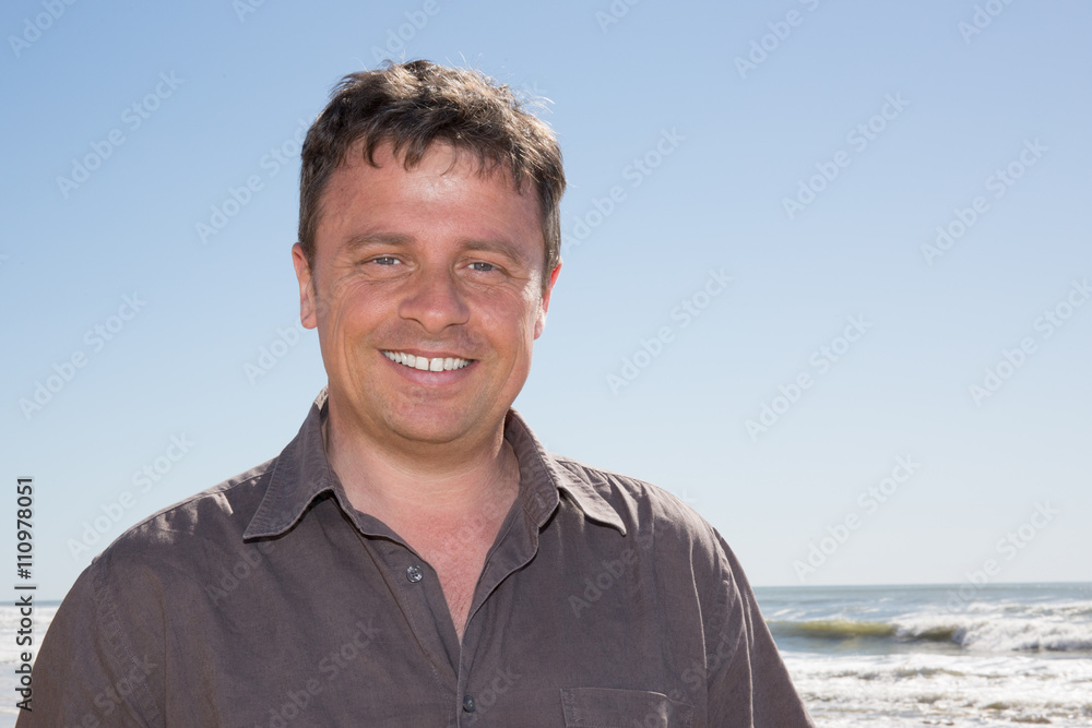 Portrait of rugged middle aged man standing at the beach Portrait of rugged middle aged man standing at the beach