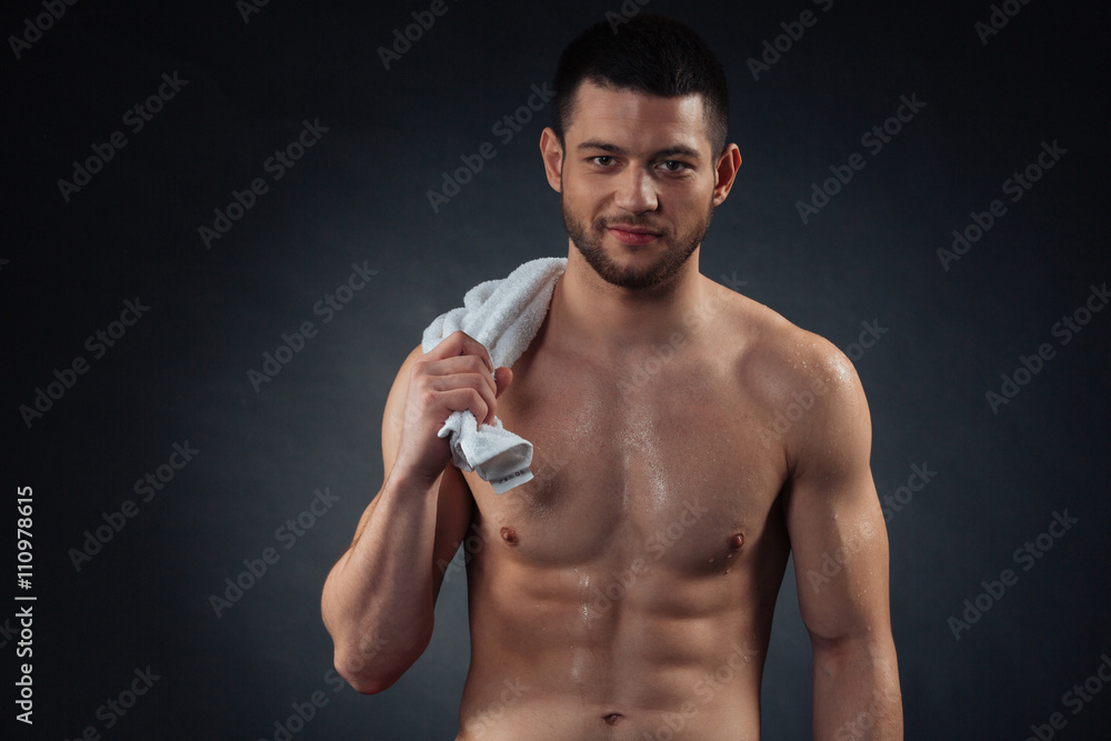 Handsome fitness man holding towel and looking at camera Handsome fitness man holding towel and looking at camera