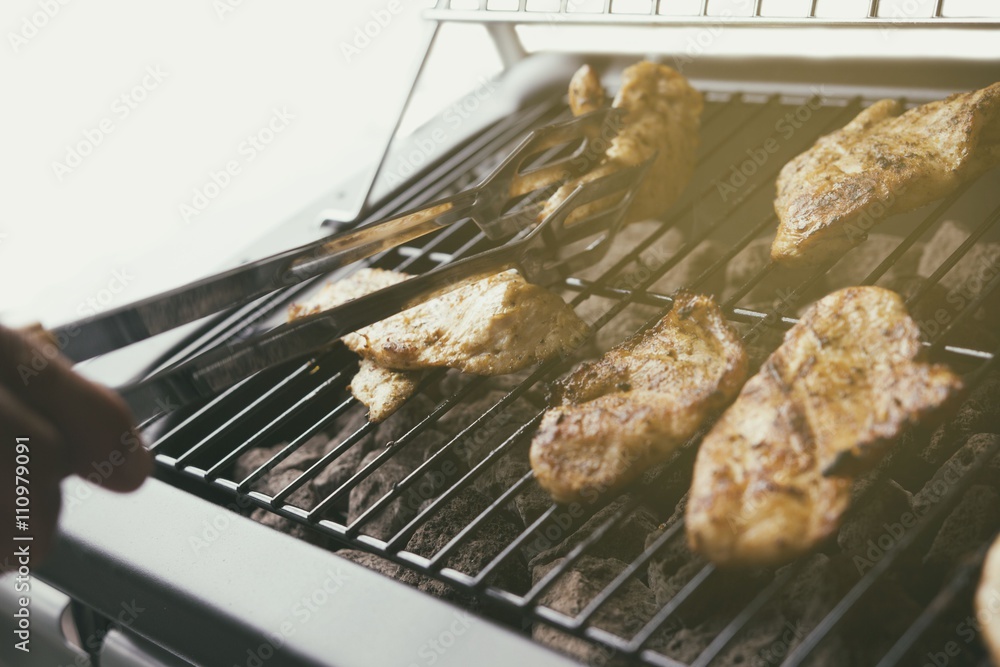 Grilled chicken on the gas grill on the garden, white background