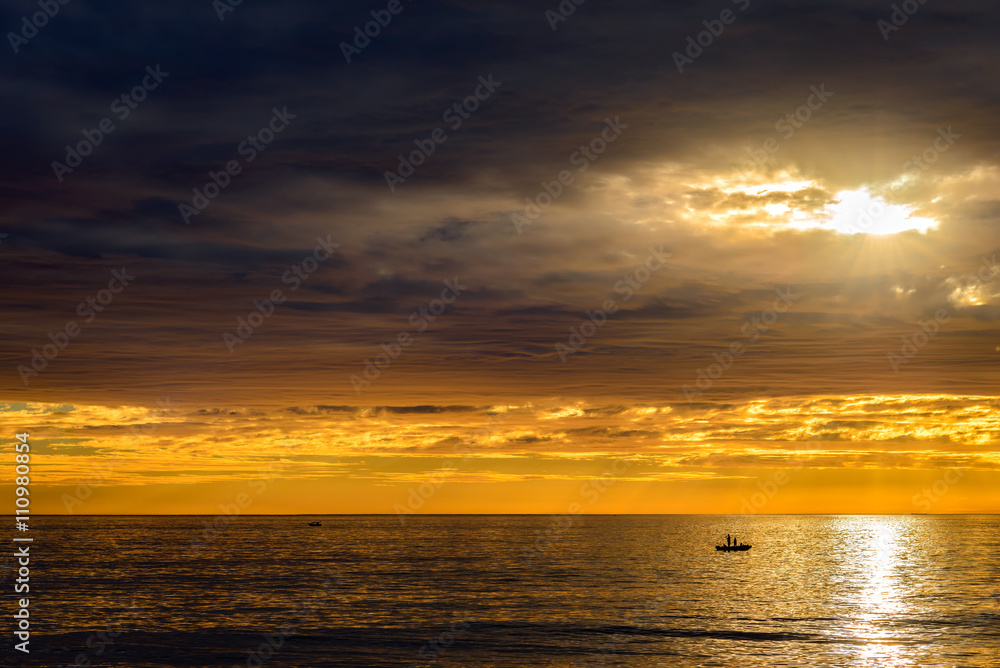 Obraz premium Boat with fishermen at sunset