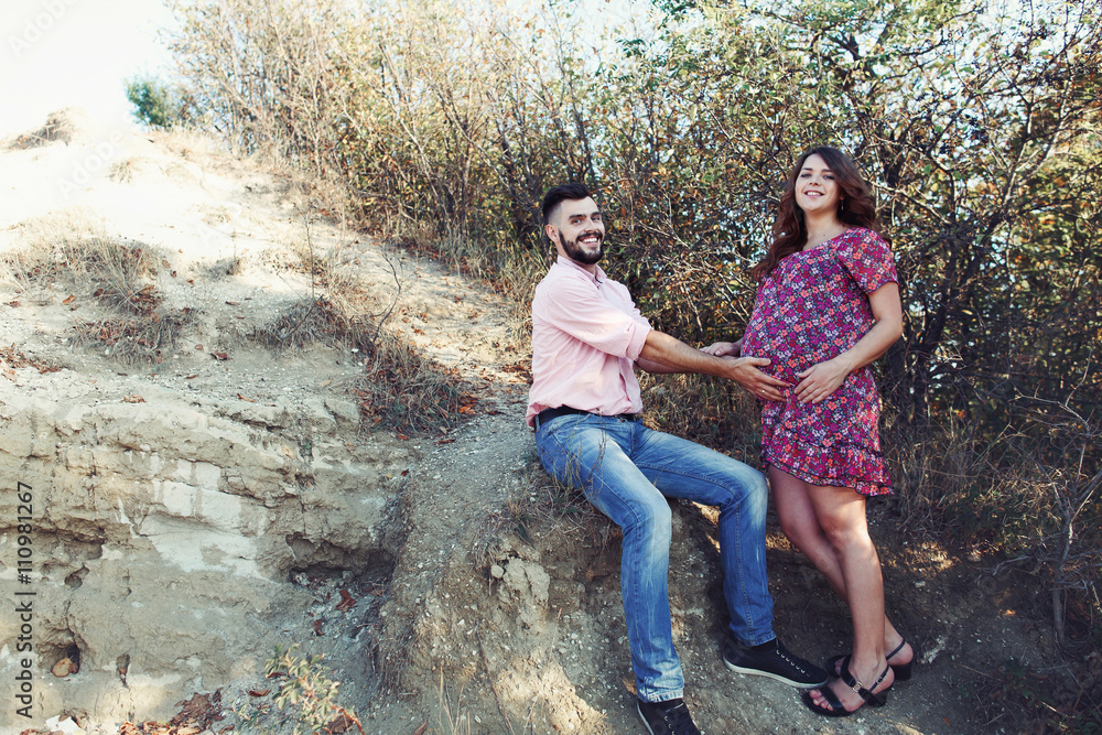 Happy smiling husband touching pregnant wife belly outdoor Happy smiling husband touching pregnant wife belly outdoor